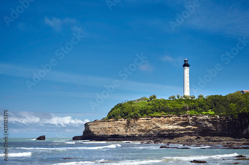 Biarritz, France. Sand beach Miramar Plage overlooking the white lighthouse - Phare de Biarritz on the Pointe Saint-Martin. Bay of Biscay, Atlantic coast, Basque country. Sunny summer day