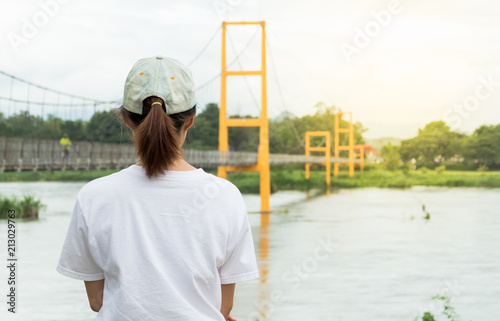 a woman looking at a suspension bridge