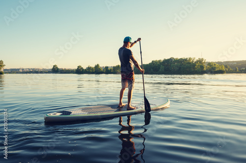 Guy paddling on a SUP board on large river