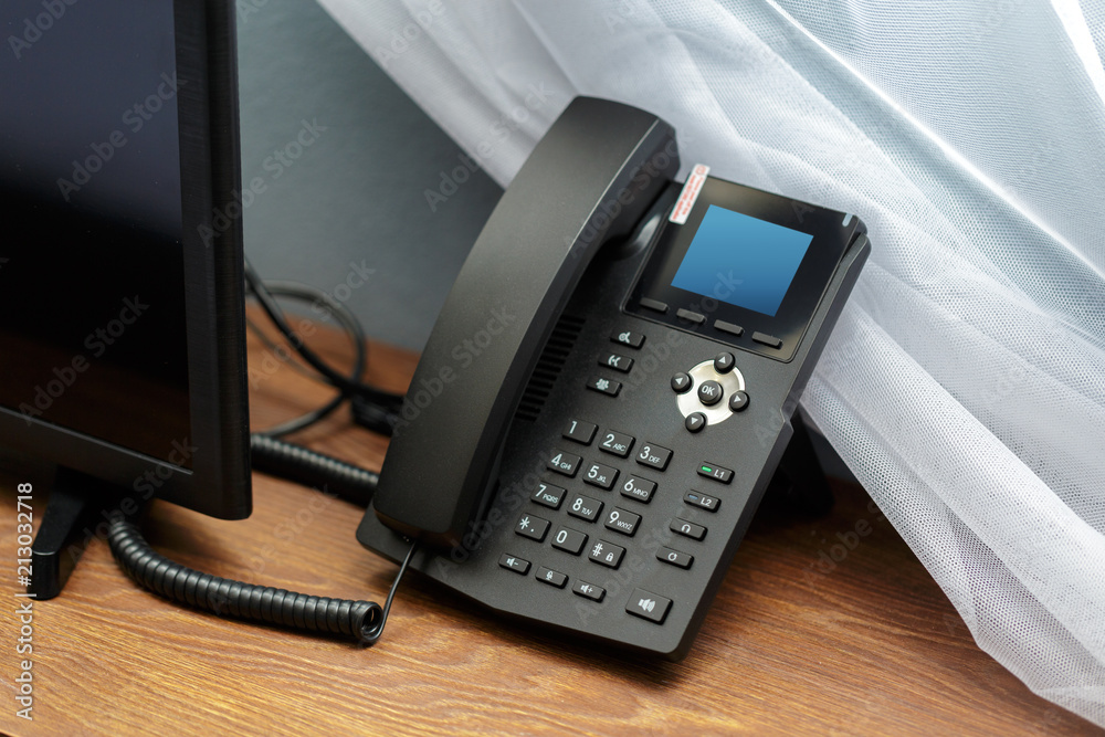 Closeup shot of a telephone receiver with buttons and texts on it in a hotel room. Closeup shot of a telephone receiver with buttons and texts on it in a hotel room.