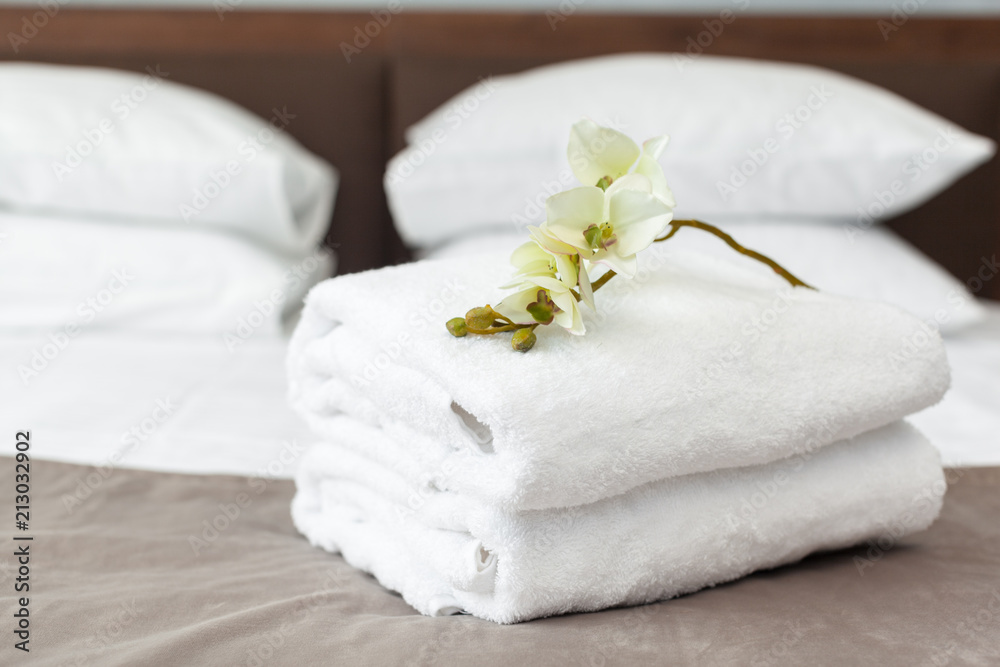 towels and flower on bed in hotel room towels and flower on bed in hotel room