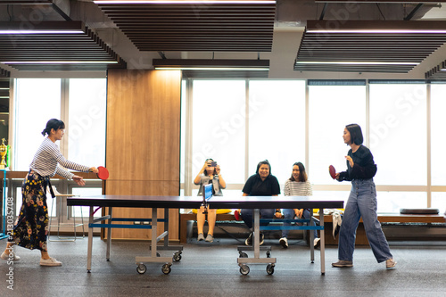 Girls is playing table tennis at the office.