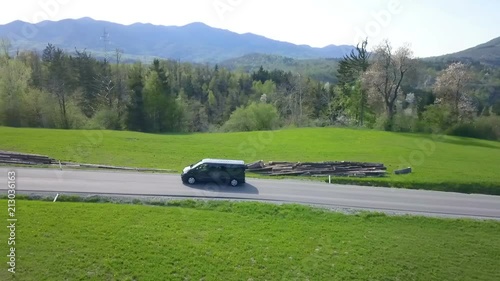Wallpaper Mural A black van is slowly driving on the road in the countryside. Aerial shot. Torontodigital.ca