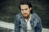  A large-sized portrait of a bearded dark-haired guy in a blue jeans similar to Jared Leto