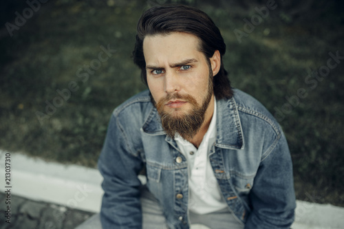 Tableau sur toile A large-sized portrait of a bearded dark-haired guy in a blue jeans similar to