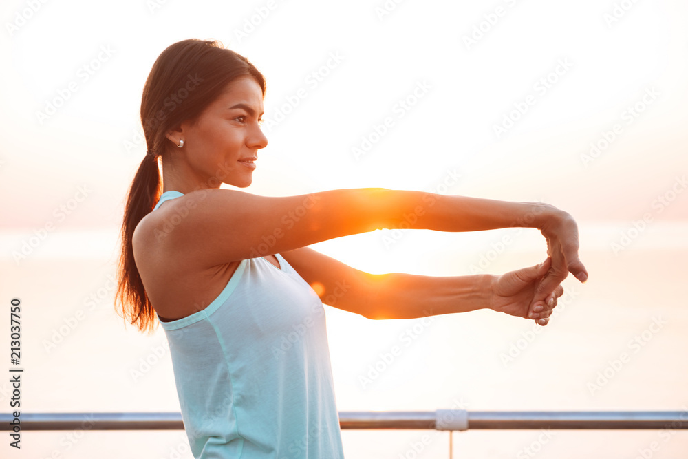 Young sports woman outdoors on the beach make sport exercises Young sports woman outdoors on the beach make sport exercises