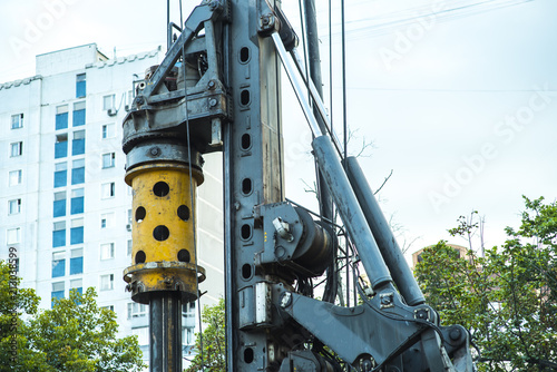 Drilling rig boring hole in city at construction site photo