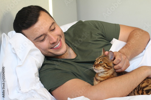 Cute ethnic man sleeping with his cat