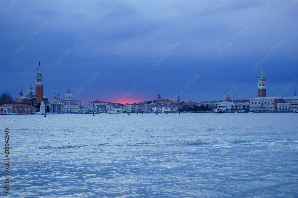 Dramatic red sunset against a blue sky at sunset over the heart of Venice, Italy with classic view of St Marks and St Michael
