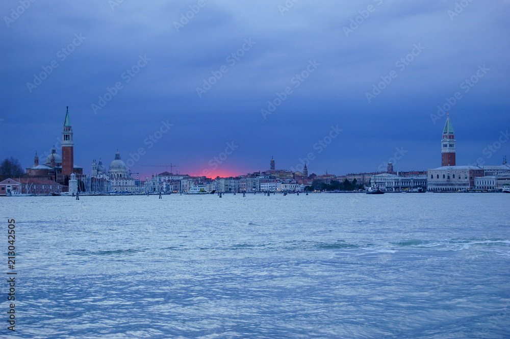 Dramatic red sunset against a blue sky at sunset over the heart of Venice, Italy with classic view of St Marks and St Michael Dramatic red sunset against a blue sky at sunset over the heart of Venice, Italy with classic view of St Marks and St Michael