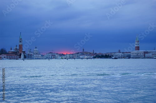 Dramatic red sunset against a blue sky at sunset over the heart of Venice, Italy with classic view of St Marks and St Michael