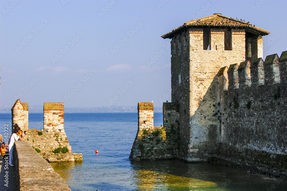 The walled and fortified inner harbour and watch tower in the walled town of Sirmione, Lombardy, Italy