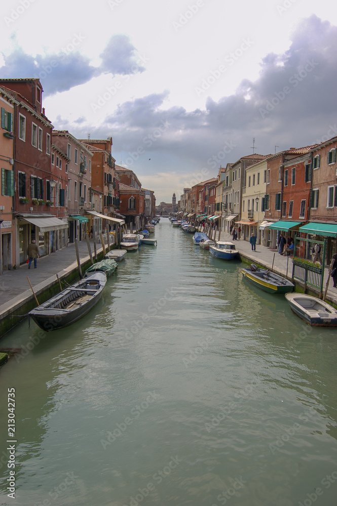 Classic view along side canal on Venice showing 3 storey houses either side of a working canal, Venice, Italy