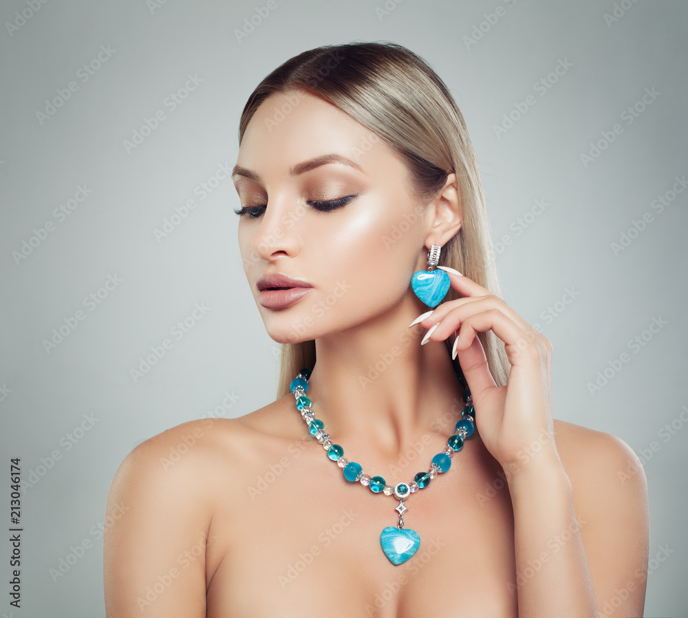 Beautiful Blonde Woman in Jewelry Necklace and Earrings with Diamonds and Turquoise Gem, Fashion Beauty Portrait. Makeup and Blonde Hair