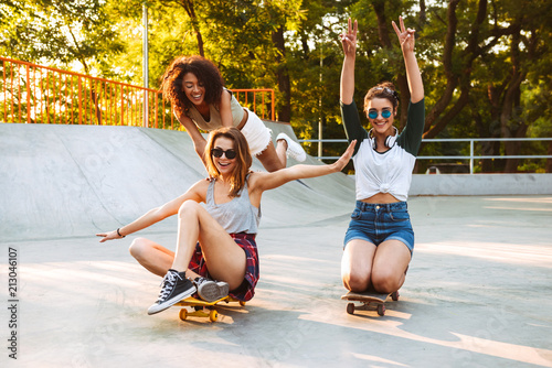 Three excited young girls with skateboards