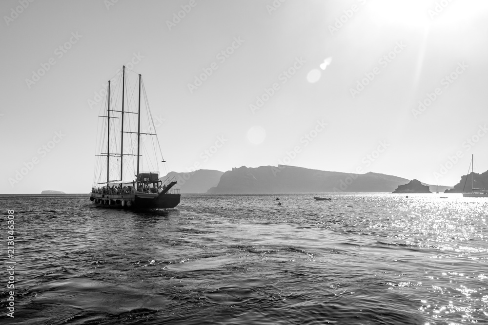 Tourist boat sailing away in Santorini, Greece. Amazing daytime view