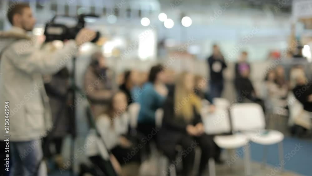 Blurred silhouette of the videographer. He shoots a fashion show. Blurred silhouette of the videographer. He shoots a fashion show.