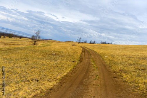 Track winding back roads in the mountains. Dirt road on Olkhon island in lake Baikal. photo