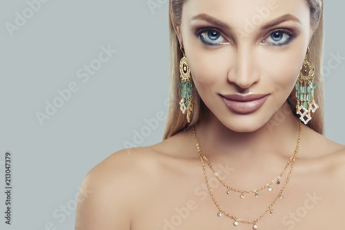 Fashion portrait of blonde woman with makeup and jewelry necklace, face closeup