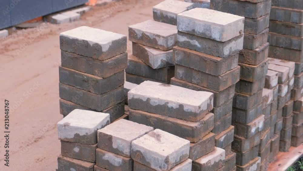 Laying paving slabs in front of the building. Sand and paving slabs in rows. Close-up view. Laying paving slabs in front of the building. Sand and paving slabs in rows. Close-up view.