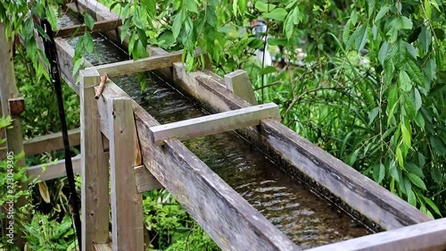 The water mill drive. The wooden trough brings water to the water mill wheel. Ancient irrigation system in an old village at farm.
