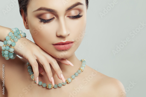 Female face closeup. Manicure, bijou and makeup. Beautiful girl portrait