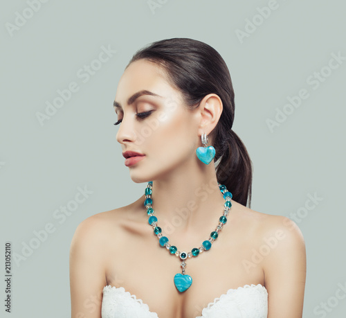 Cute Young Woman with Makeup, Silver Necklace and Earrings with Diamond and Blue Stones