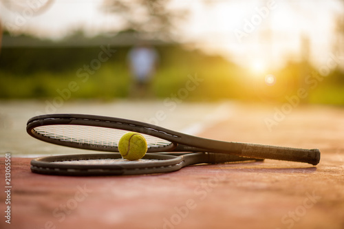 Tennis ball and racket on hard court under sunlight © Day Of Victory Stu.