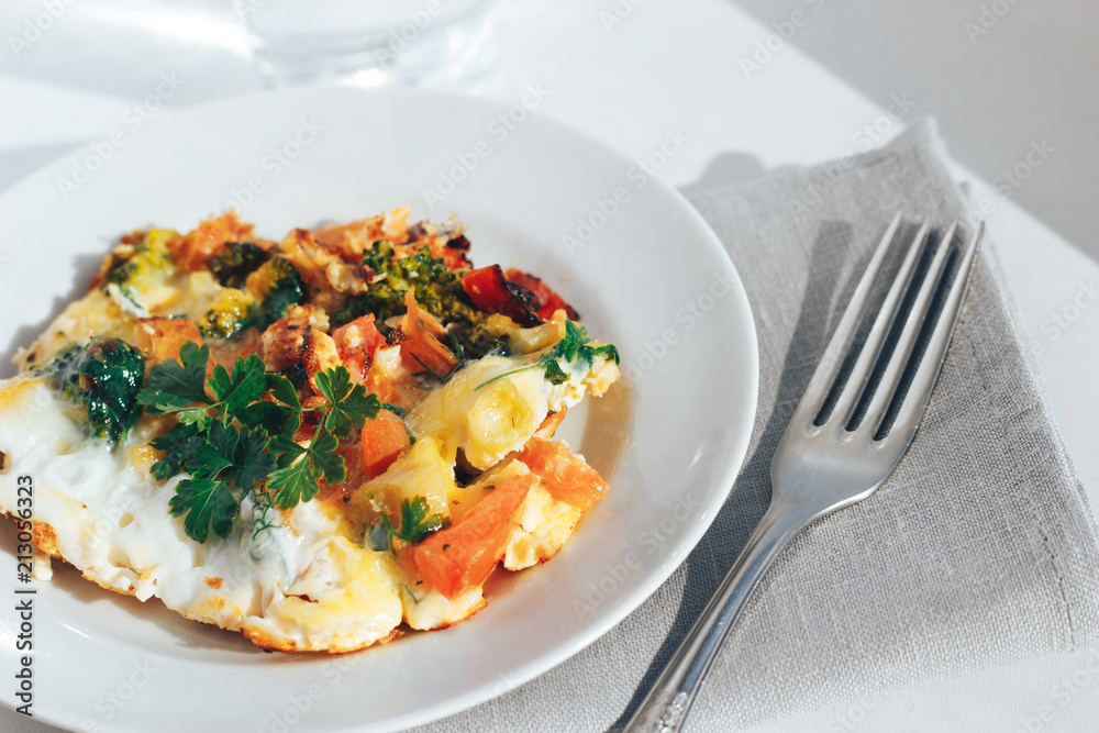 Scrambled eggs with tomatoes and greens on an white background