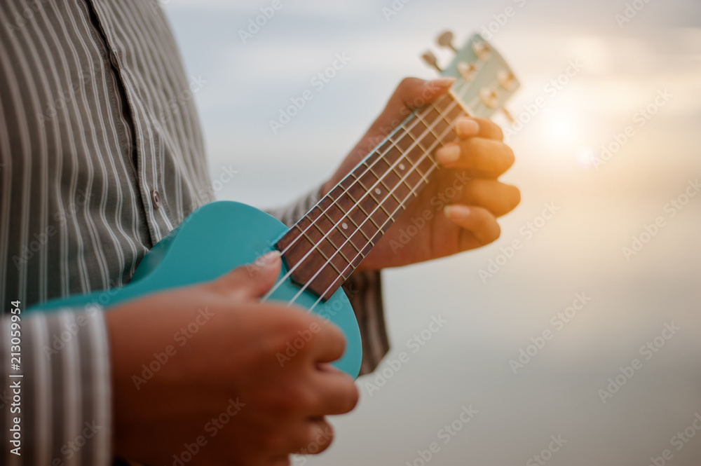 Fototapeta premium Man playing ukulele at the beach