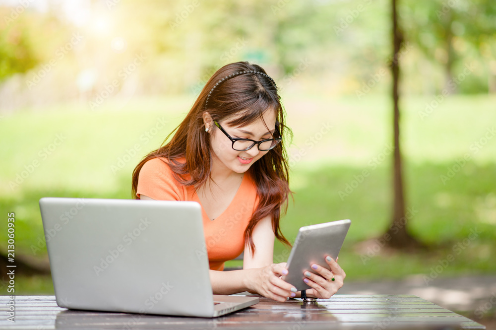 Young beautiful Asian woman working at outdoor park,happy relaxing. owner business woman work at outdoor park.internet and technology concept. Young beautiful Asian woman working at outdoor park,happy relaxing. owner business woman work at outdoor park.internet and technology concept.