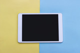 abstract colored paper, pastel yellow and blue background, empty tablet, mock up