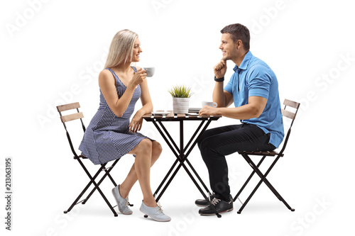 Young woman and a young man seated at a coffee table