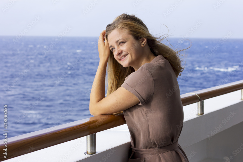 A young girl on a big liner. Beautiful girl in the open ocean. Rest on the sea. Seaside vacation.
