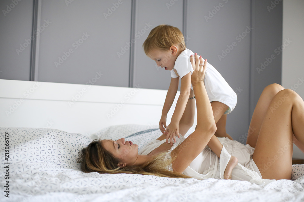 Naklejka premium Young mother with son in the bed