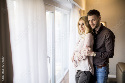 Young couple standing by the window in the room