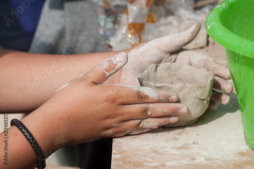 closeup of hands of child making clay pottery bowl in outdoor