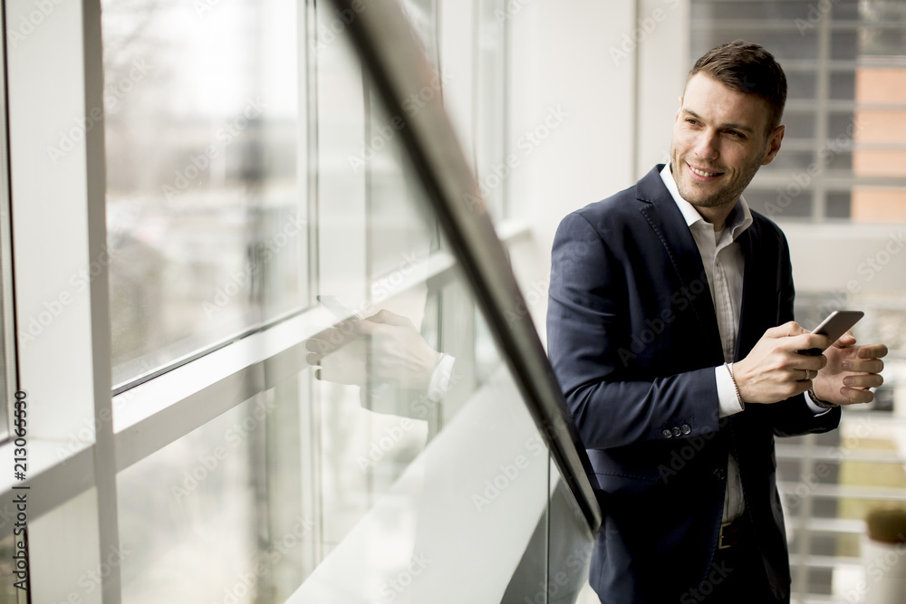 Handsome businessman using smartphone in the office