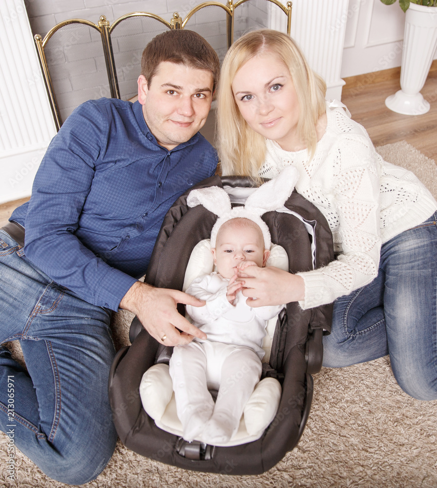 happy parents and year-old child in a Bunny suit in the living room happy parents and year-old child in a Bunny suit in the living room