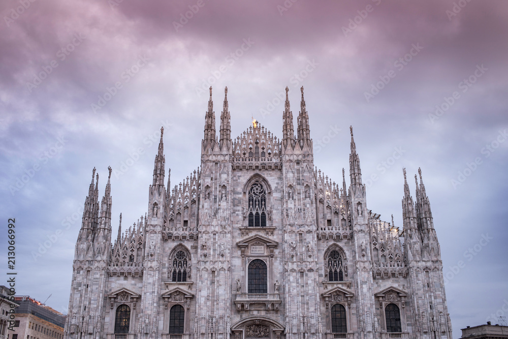 The great Duomo of Milan in twilight with blurred people in the square