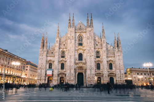 The great Duomo of Milan in twilight with blurred people in the square