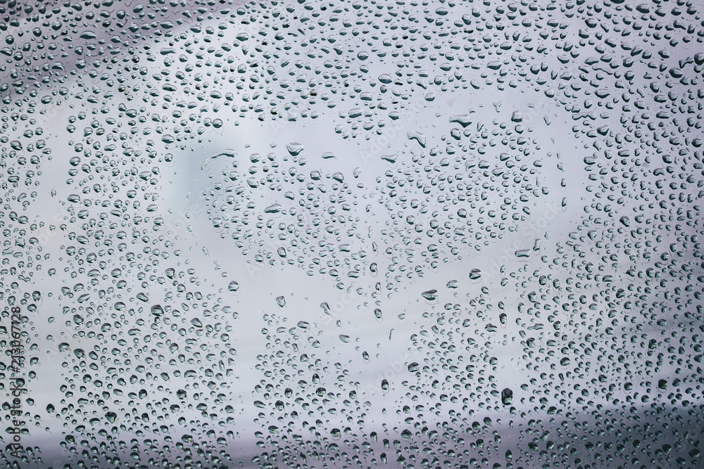 Heart and raindrops. Drawn romantic blurred love symbol drawn by hand on the wet window glass, light background Heart and raindrops. Drawn romantic blurred love symbol drawn by hand on the wet window glass, light background
