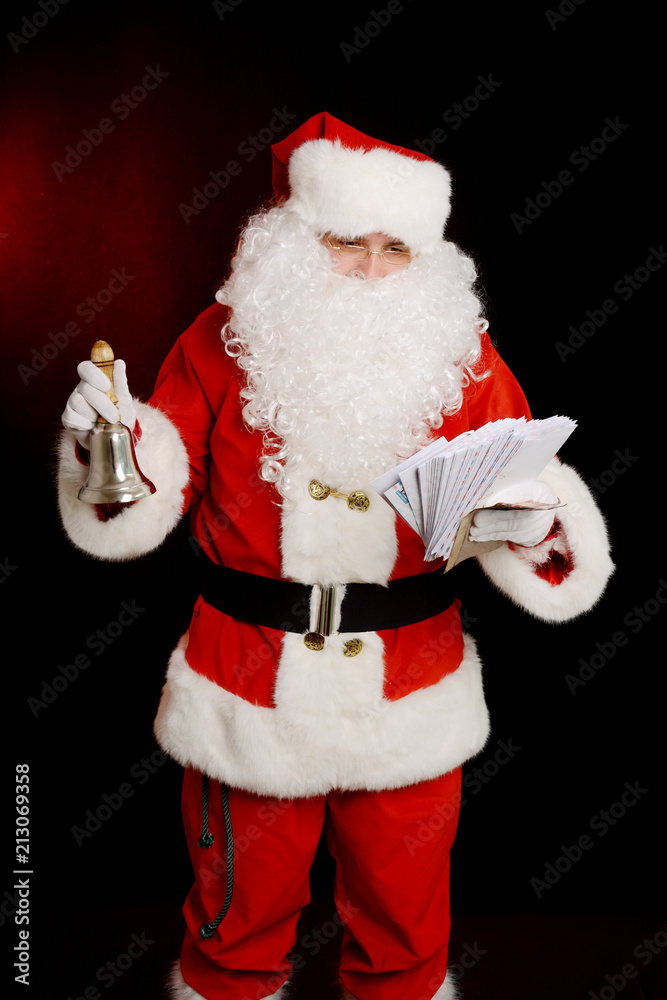 Santa Claus holding hand bell and children's letters Santa Claus holding hand bell and children's letters