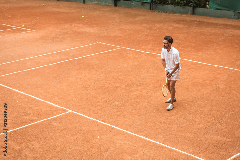 retro styled tennis player with racket playing game on tennis court