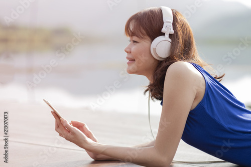 one woman listening music at the lake