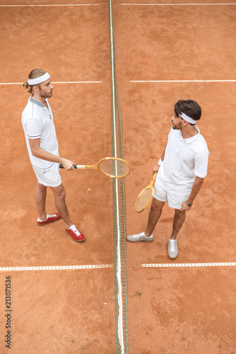 tennis players with retro wooden rackets on court together © LIGHTFIELD STUDIOS