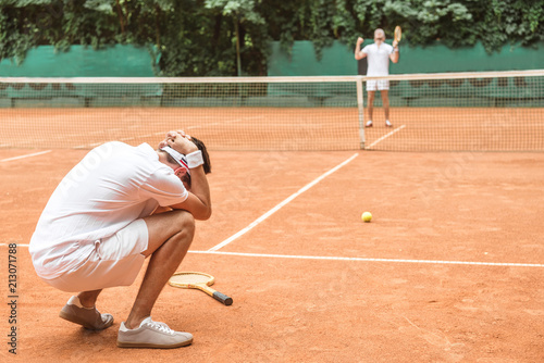 frustrated tennis player after fail on brown tennis court © LIGHTFIELD STUDIOS