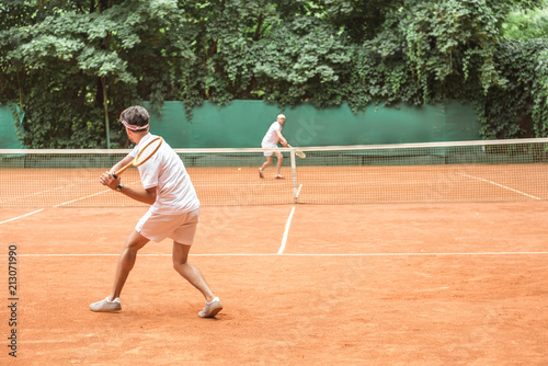 sportsmen playing tennis with wooden rackets on court together © LIGHTFIELD STUDIOS