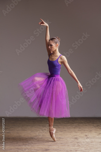 Young beautiful ballerina is posing in studio