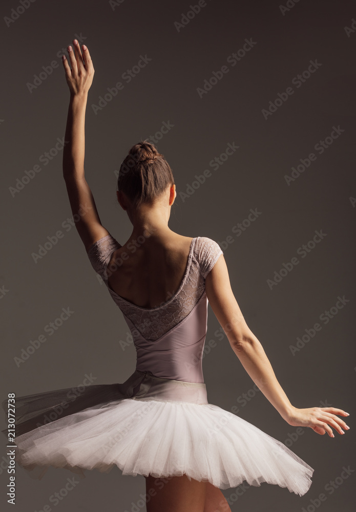 Young beautiful ballerina is posing in studio